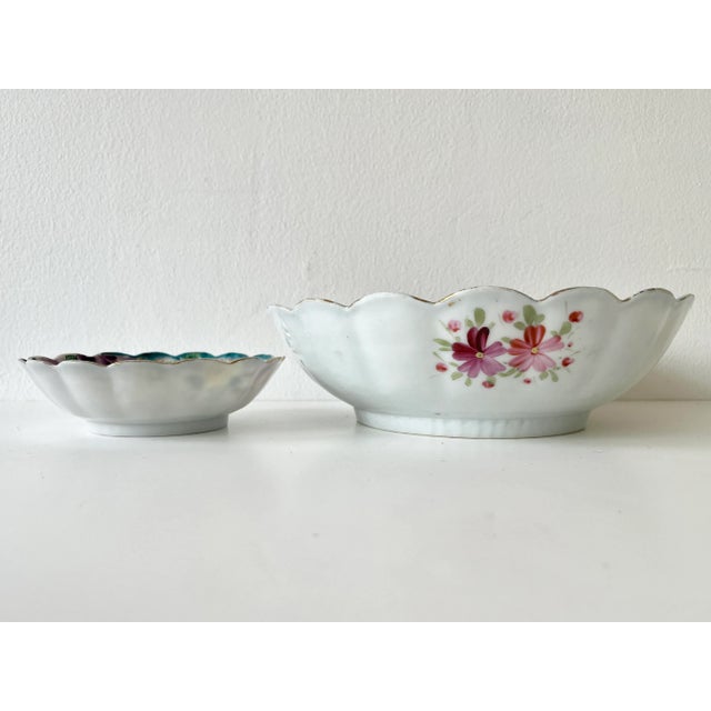 A set of antique hand-painted European porcelain bowls, early 20th century. The set includes a wide and shallow serving...