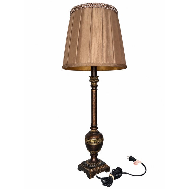 A decorative buffet-style table lamp combining a slender column with an urn-shaped lower body and a square architectural...