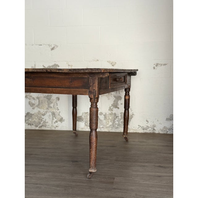An 18th century Continental European primitive table with a single drawer and turned ring-and-reel legs. Hand cut early...