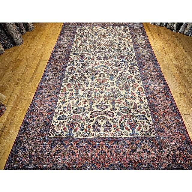 This spectacular vintage oversized Persian Kerman Lavar, woven in the early 20th century in an allover floral vase...