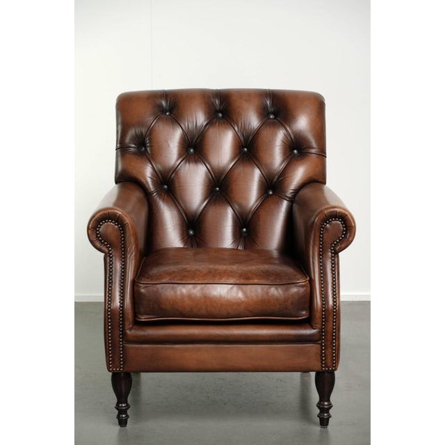 This very beautiful Chesterfield armchair, which is in good condition, is made of cowhide leather and features warm,...