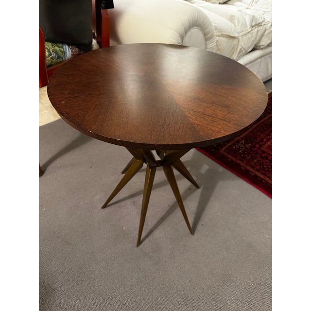 Heritage Home accent table with a round wood top and brass metal base that adds a mid-century inspired look. Light surface...