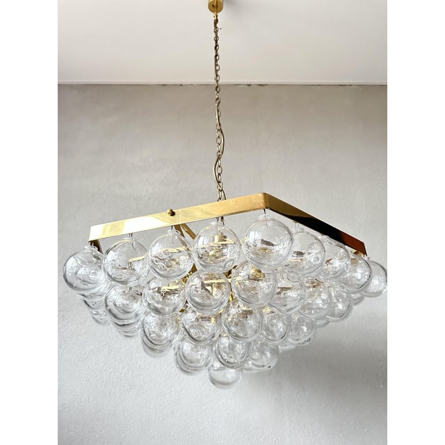Beautiful mid-century design. 1970s chandelier made by the German company Kaiser Leuchten. It has a four-tiered brass...