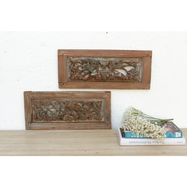 The antique carved wooden panels, likely originating from Southeast Asia, appear to be fragments from a larger...