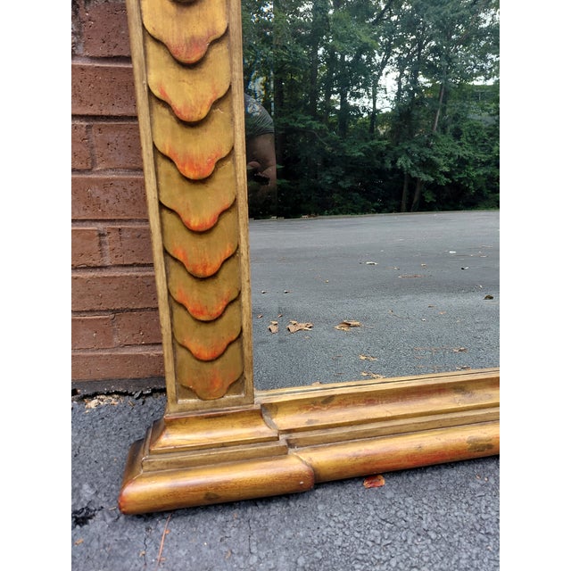 Impressive full-length mirror featuring a richly gilded architectural frame with layered molding, geometric details,...