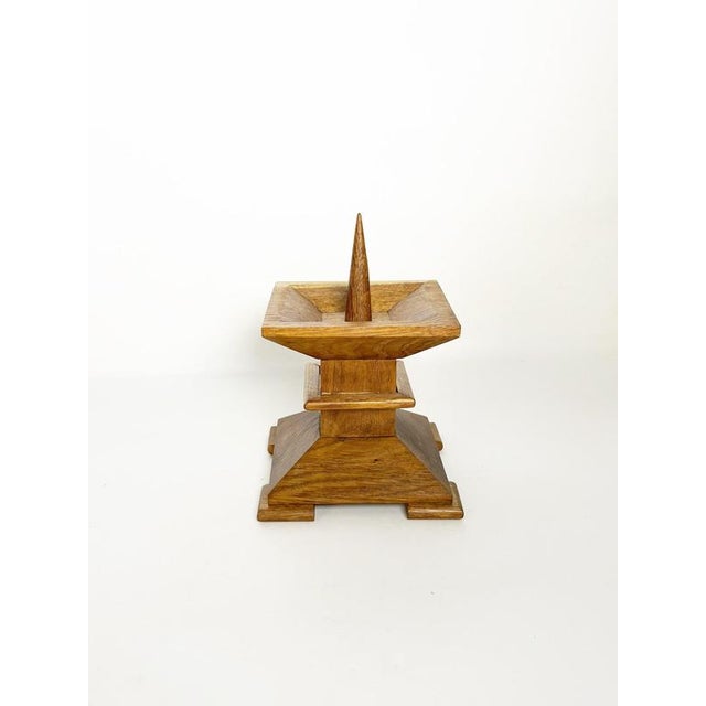 French candle holder dating from the 1940s, crafted from solid oak with a warm natural finish. The piece features a...