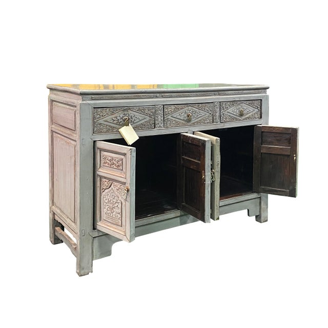 This is a console sideboard cabinet with oriental relief carving of flowers on the front apron. The surface is finished...