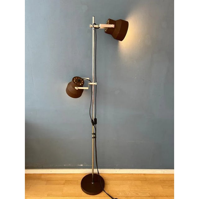 Brown mid century Anvia floor lamp with two adjustable shades. The two brown aluminium spots can be moved up and down the...