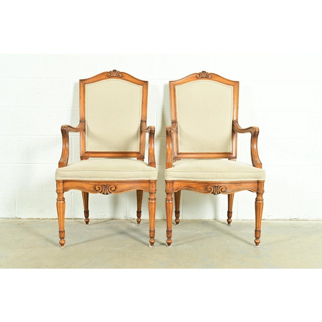 A gorgeous pair of French Regency Louis XVI style armchairs or dining captain chairs In the manner of Baker Furniture USA,...