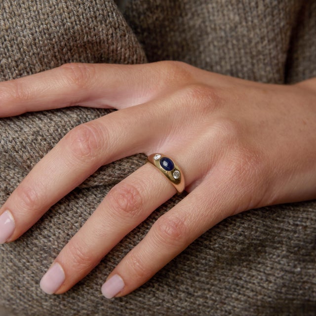 A bold vintage statement from the 1980s, this striking ring centers on a richly colored cabochon sapphire, its smooth...