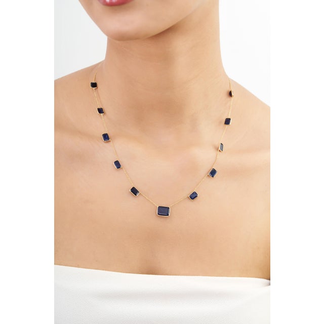 This modern station necklace features 16.19 carats of vibrant natural blue sapphires, set in rich 18k yellow gold. The...
