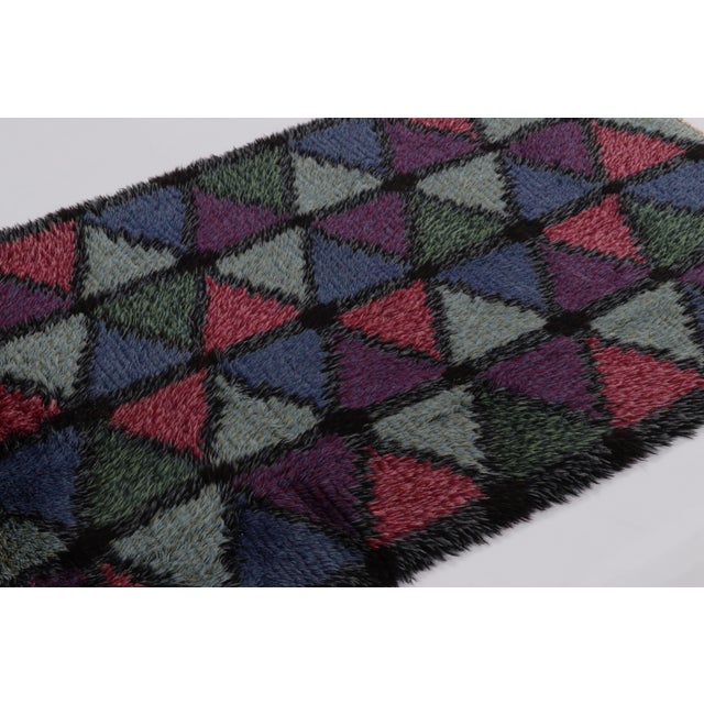 Hand-knotted in lush, high-pile wool in Sweden circa 1960-1970, this 4x6 vintage Swedish Rya rug is a bold new addition to...