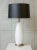 An elegant pair of Italian Mid-Century Murano glass table lamps featuring frosted white glass bodies accented by antique...