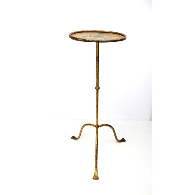 Gilt tripod Martini side table, circa 1950. Wrought iron with gold leaf covering. Round top with a raised edge. Elegant...