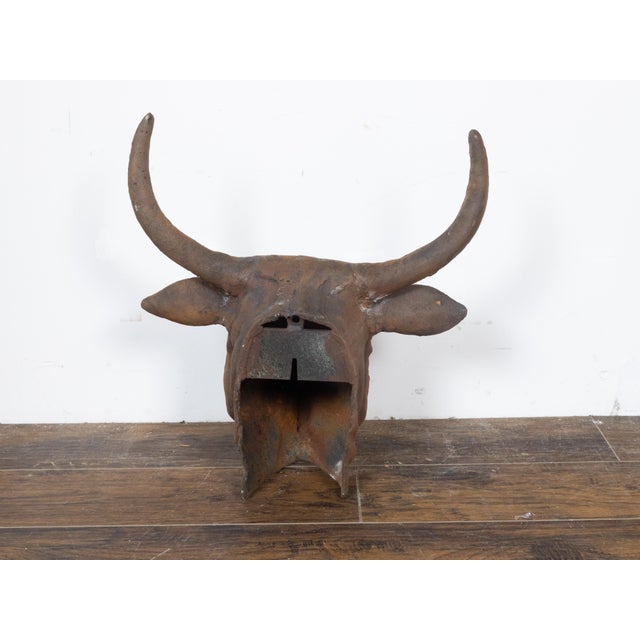 This English cast iron bull wall hanging sculpture, dating back to circa 1930-1940, presenting large antlers and a rustic,...