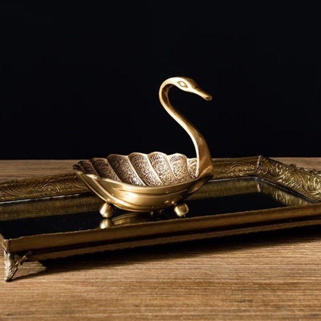 This vintage-style storage tray features an aged gold finish and a graceful swan shape—the swan's body forms the tray's...