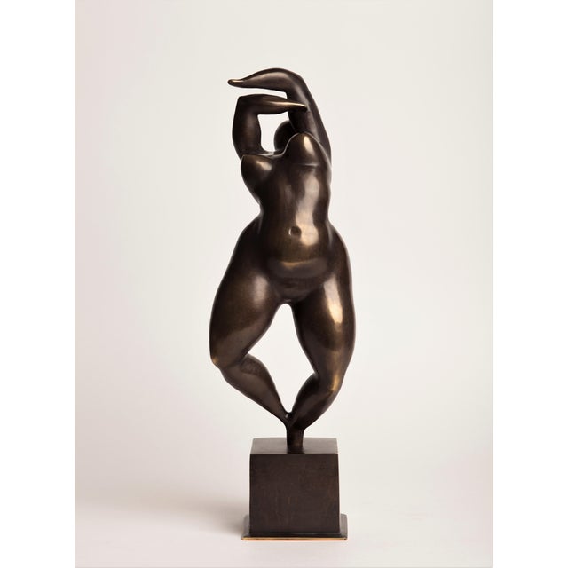 A contemporary figurative bronze of a standing woman, arms raised and arched overhead, the body stretched into a single...