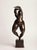 A contemporary figurative bronze of a standing woman, arms raised and arched overhead, the body stretched into a single...