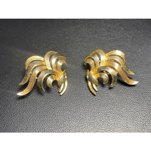 Embodying the dynamic energy of Mid-Century Modern design, these vintage Trifari clip-on earrings feature an expressive,...