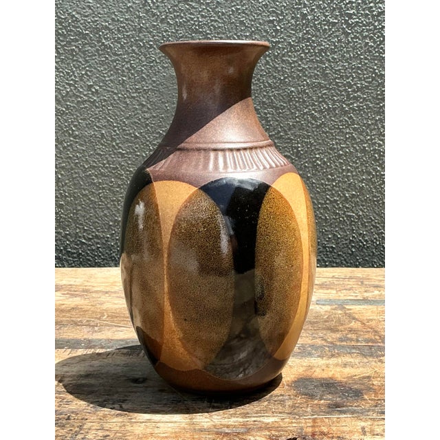 This striking vintage studio pottery vase perfectly captures the earthy, modernist aesthetic of the 1970s craft movement....