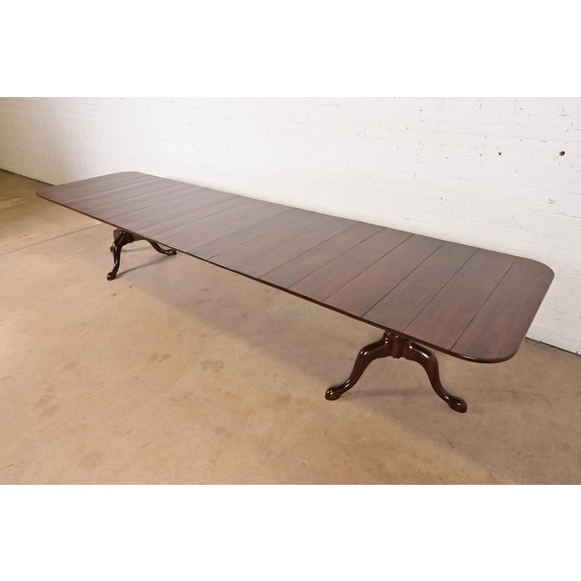 A gorgeous monumental Georgian, Regency, or Queen Anne style solid cherry wood double pedestal extension dining table In...