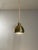 Suspension lamp with lampshade in polished gold-coloured metal. Electrical wire covered in brown fabric. The wire is...