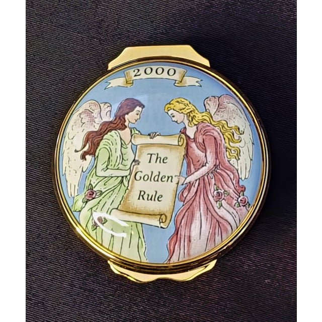 Halcyon Days Enamels Trinket Box Featuring Two Angels Holding a Scroll Which Reads: The Golden Rule. Every enamel box is...