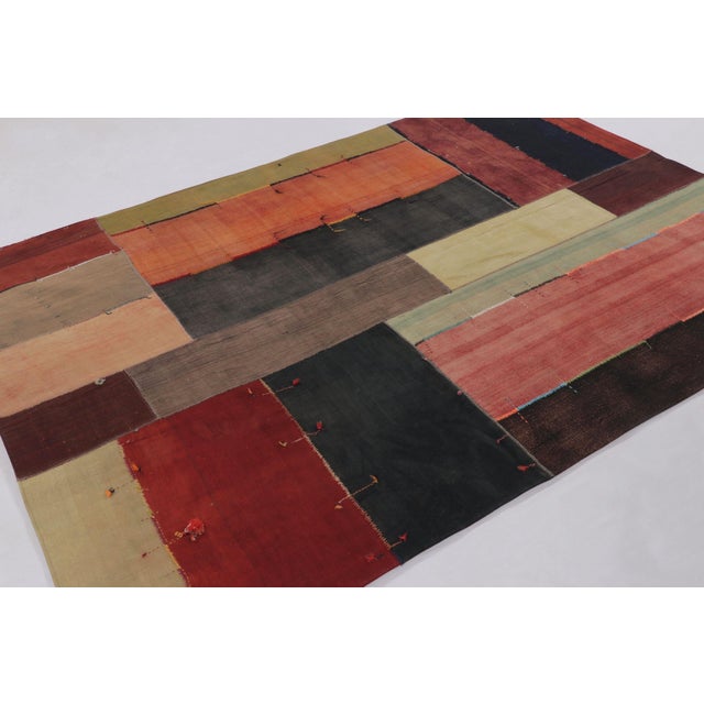 Handwoven in cotton and wool, this 6x8 vintage patchwork rug, circa 1950-1960, is a compelling example of mid-century...