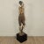 A 19th-century Southeast Asian tall painted and carved wood figure of a man, with wear and losses, on later stand. The man...