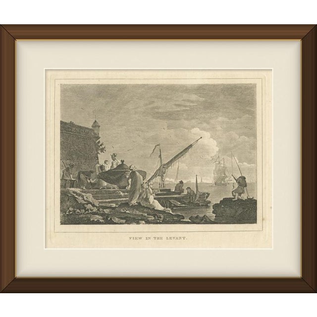 This antique engraving titled "View in the Levant" shows a harbour quay beneath a massive fortress wall, with turbaned...