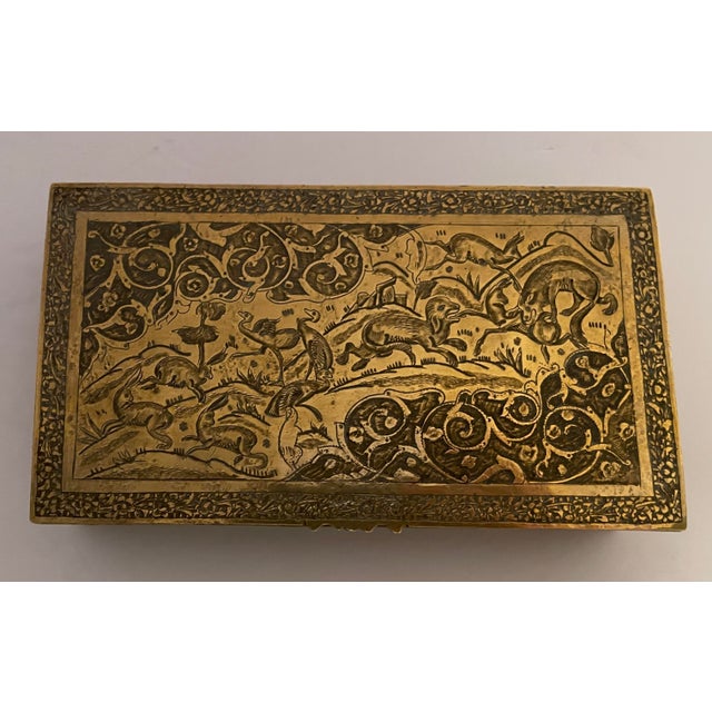 1930s lidded brass box, heavily engraved with a hunting scene on the top consisting of rabbits, sheep, birds and an...