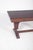 Rectangular extendable dining table. The top has straight edges with a stepped profile, showing a geometric design...