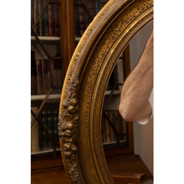 This is a classic American sand gilt oval portrait frame make of carved wood and decorative composite ornamentation, circa...