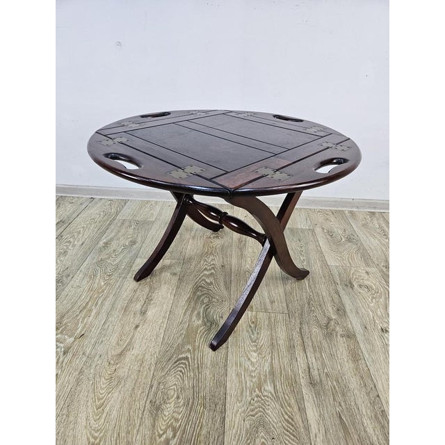 A table made in England, dating from the 1970s. The table top has brass hinges and handles and can be used as a tray. The...