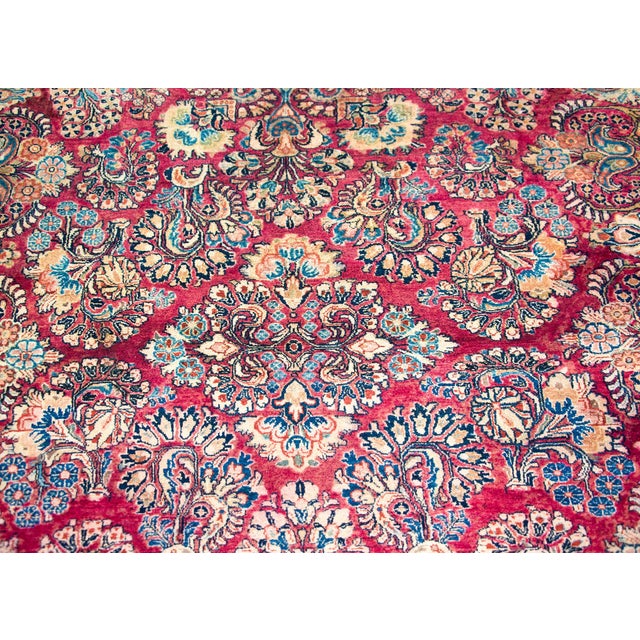 A beautiful early 20th century Persian Sarouk rug with an all-over large-scale mirrored floral cluster pattern with myriad...
