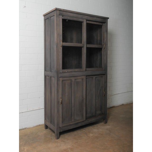 A grounded, architectural form rendered in a deep charcoal wash, this cabinet balances transparency and solidity through...