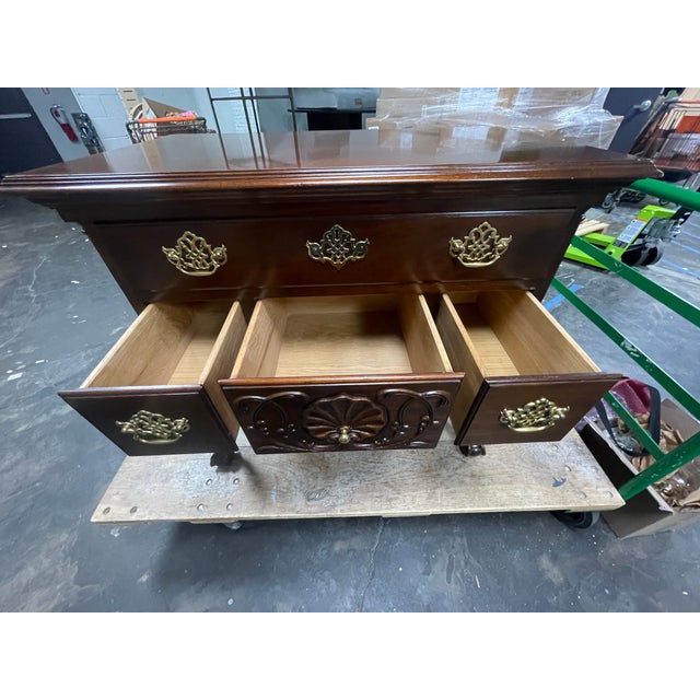 This piece is a reproduction of a Philadelphia Chippendale-style lowboy, crafted in mahogany with decorative brass...