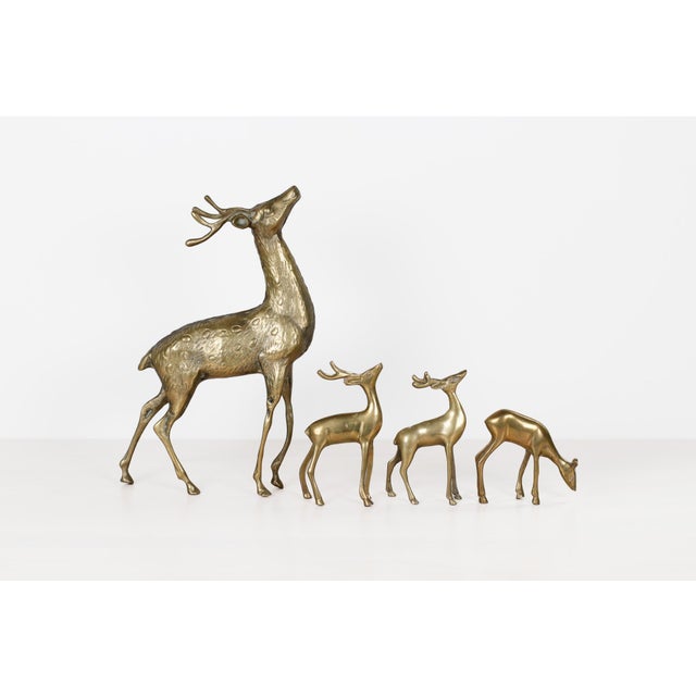 Vintage set of four solid brass deer figurines in varying sizes and poses: a stunning large stag with head raised and full...