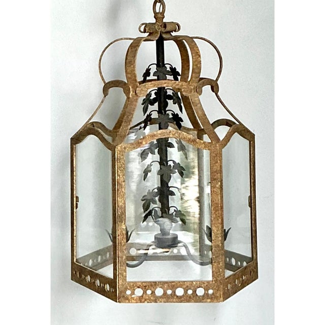 This vintage pendant lantern is a tall, architectural form with a hexagonal glass-paneled body beneath a sweeping, crown-...