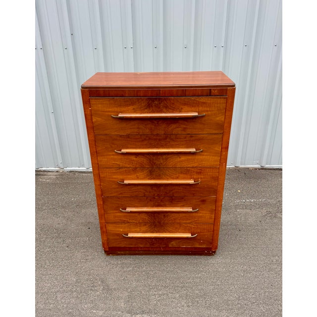 Elegant American Streamline Moderne chest featuring dramatic bookmatched walnut veneers, rounded waterfall edges, and...