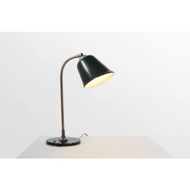 A characterful 1920s French industrial desk lamp in metal, embodying the utilitarian elegance of early 20th‑century...