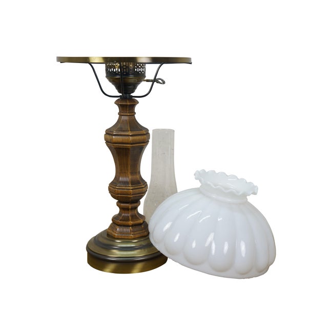 Late 20th century table lamp in the style of an old converted oil lamp. Faux wood grain resin body with round brass base...