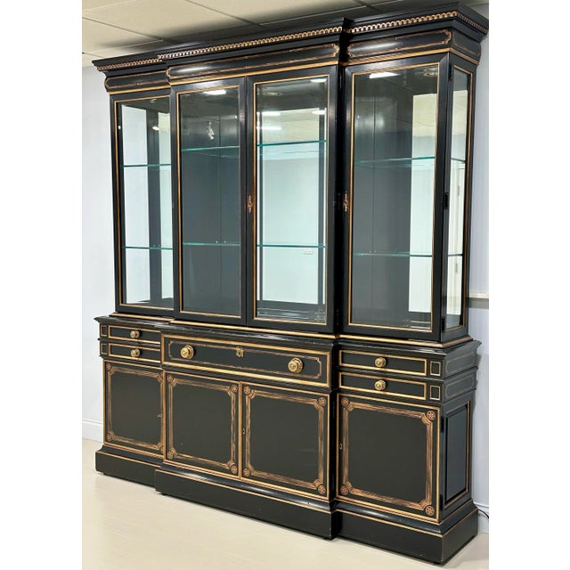 An impressive black lacquered and gilt decorated breakfront display cabinet by Karges Furniture, executed in an elegant...