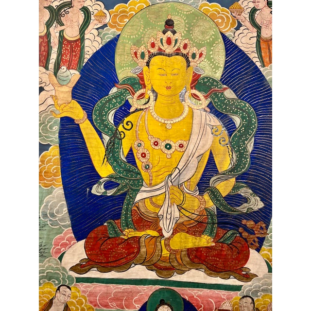 A beautiful vintage traditional Tibetan Buddhist thangka, likely painted by a Nepalese artist, depicting a richly detailed...