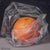 Orange Wrapped in Plastic by Kelly Birkenruth | Oil on Panel Still life of an orange in plastic wrap For Sale