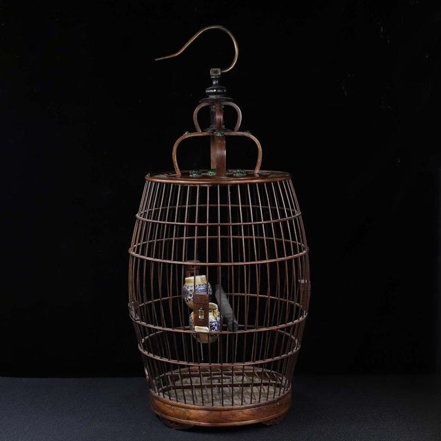 This is a substantial and exquisitely crafted wooden birdcage, featuring an elegant, barrel-shaped body and a domed top....
