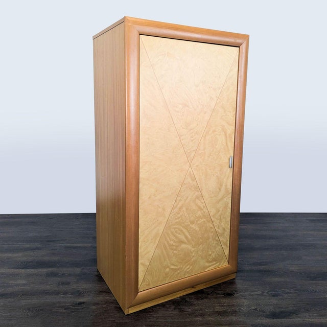 Cabinet with three drawers and upper shelf. The cabinet features light wood with inlay design on door and metal hardware....