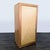 Cabinet with three drawers and upper shelf. The cabinet features light wood with inlay design on door and metal hardware....