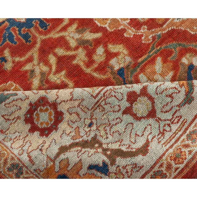 An early 20th century antique Sultanabad rug, the rust field with enlarged palmette and floral trellis overall within the...
