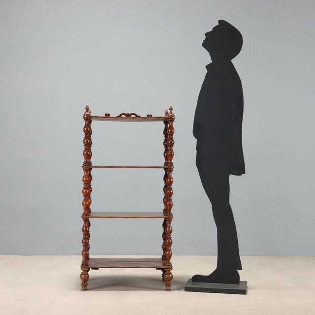 Walnut etagere dating back to the mid-19th century, featuring an elegant four-shelf structure. The turned columns, which...